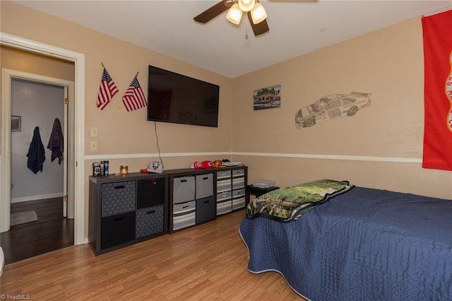 bedroom with a ceiling fan, baseboards, and wood finished floors