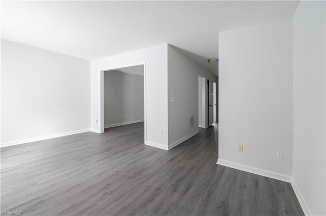 909 Shelby Dr Unit B, Greensboro, NC 27409 - spare room featuring dark wood-style floors, baseboards, and a textured ceiling