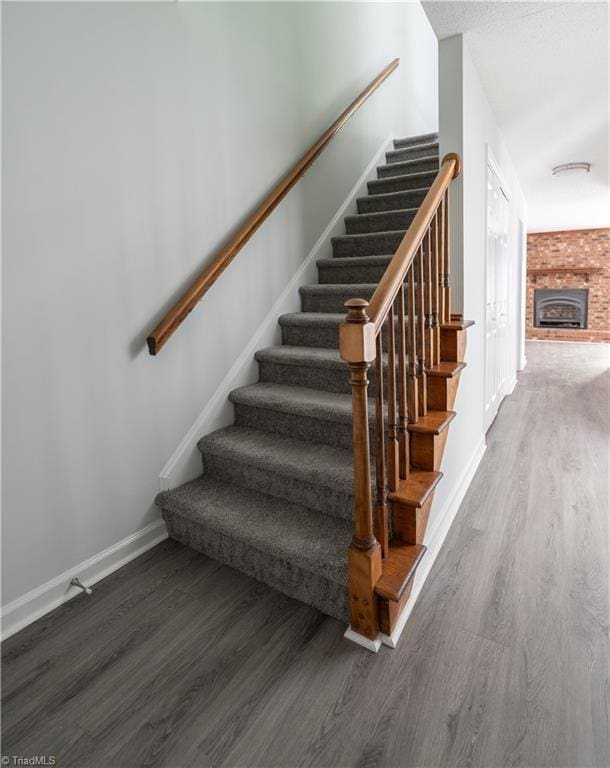 909 Shelby Dr Unit B, Greensboro, NC 27409 - stairs featuring wood finished floors, baseboards, and a fireplace
