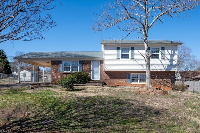 split level home with brick siding, a gate, a front yard, and fence