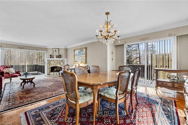 dining space featuring a notable chandelier, parquet floors, crown molding, and a fireplace