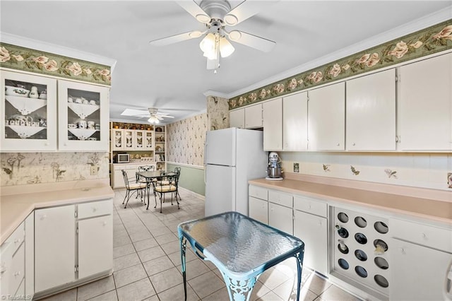 kitchen featuring white cabinets, white refrigerator, ceiling fan, and crown molding