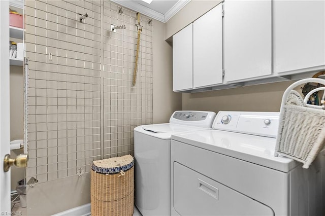 laundry area with cabinets, crown molding, and washing machine and clothes dryer