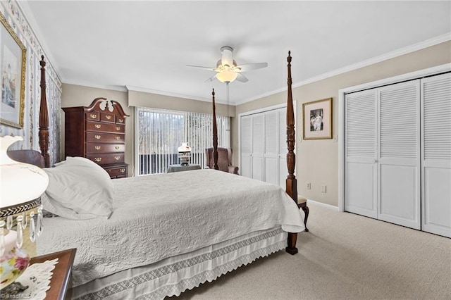 bedroom with ceiling fan, ornamental molding, two closets, and carpet