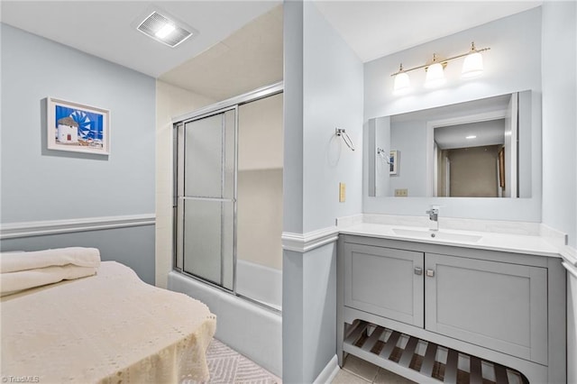 bathroom with tile patterned flooring, shower / bath combination with glass door, and vanity