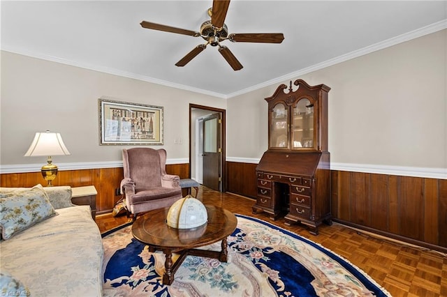 living room featuring dark parquet floors, ceiling fan, and ornamental molding