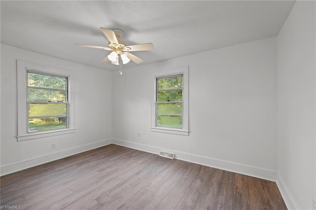 unfurnished room with hardwood / wood-style floors, plenty of natural light, and ceiling fan