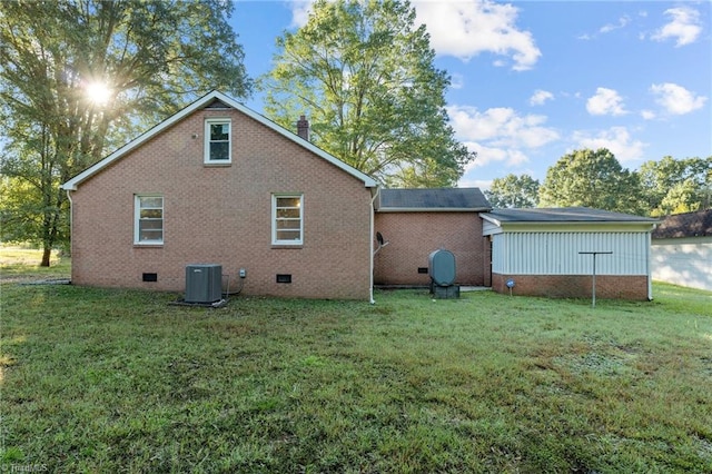 back of house featuring a yard and central AC