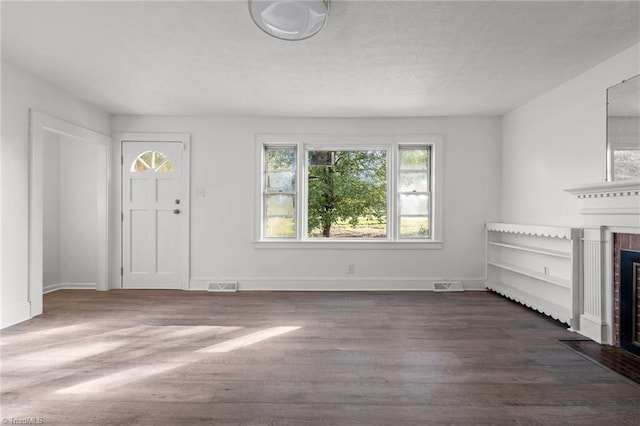 unfurnished living room featuring dark wood-type flooring and a fireplace