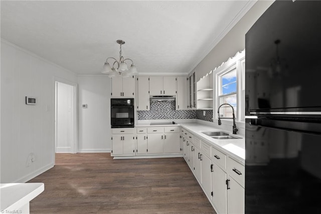 kitchen featuring sink, black appliances, white cabinetry, and pendant lighting