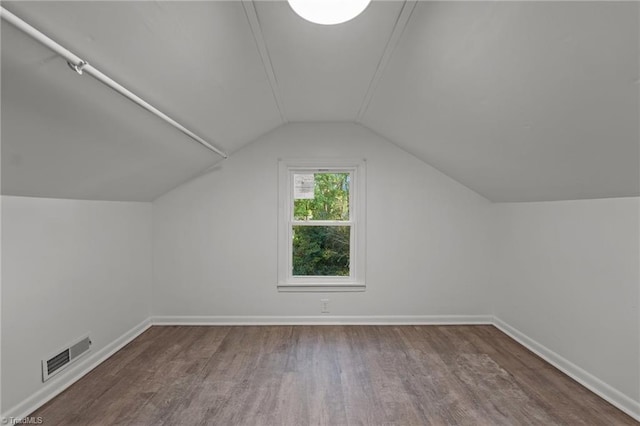 additional living space featuring hardwood / wood-style floors and vaulted ceiling