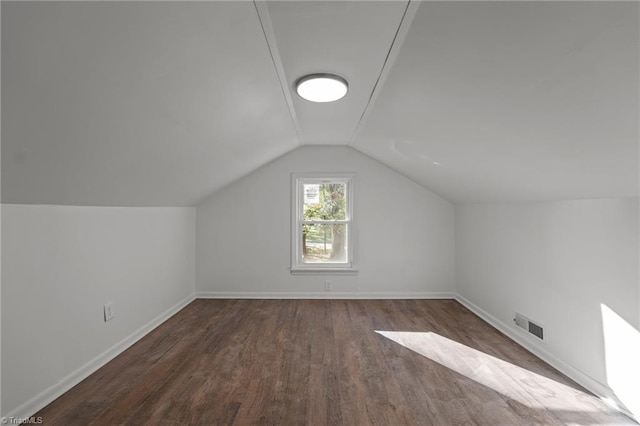 additional living space with dark hardwood / wood-style floors and vaulted ceiling