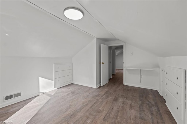 additional living space with vaulted ceiling and dark hardwood / wood-style flooring