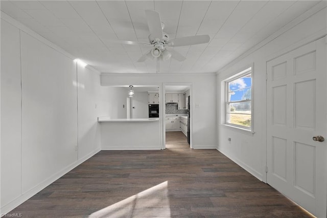 unfurnished living room featuring ceiling fan, ornamental molding, and dark hardwood / wood-style flooring