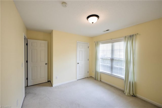 unfurnished bedroom featuring light carpet