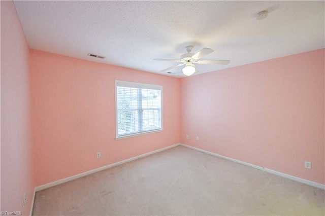 carpeted spare room featuring ceiling fan and a textured ceiling