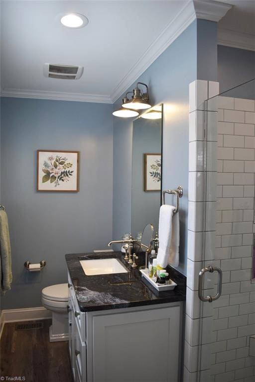 bathroom with wood-type flooring, vanity, toilet, walk in shower, and crown molding