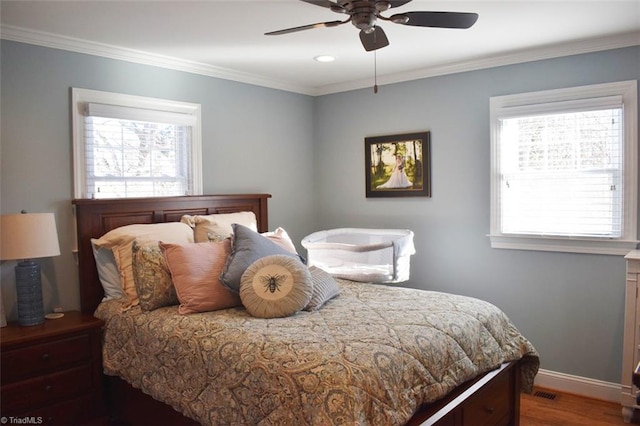 bedroom with ceiling fan, crown molding, multiple windows, and hardwood / wood-style floors