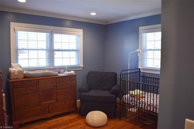 sitting room featuring ornamental molding and hardwood / wood-style flooring