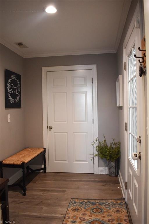 doorway featuring dark wood-type flooring and ornamental molding