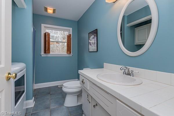 bathroom with vanity, tile patterned floors, and toilet