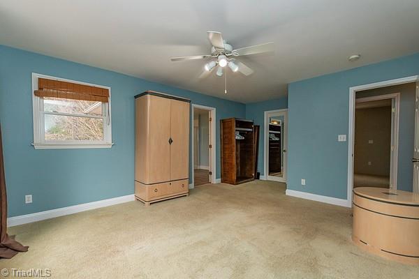 unfurnished bedroom featuring light colored carpet and ceiling fan