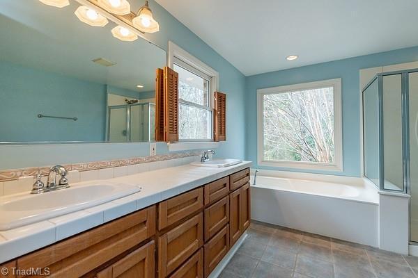 bathroom featuring vanity, separate shower and tub, tile patterned flooring, and a notable chandelier