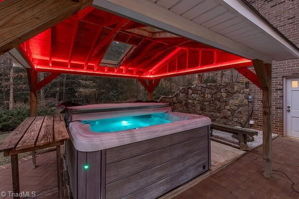 view of swimming pool with a hot tub and a gazebo