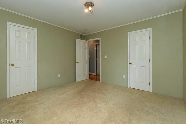 unfurnished bedroom with light carpet and ornamental molding