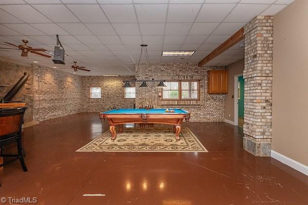 game room featuring ceiling fan, brick wall, pool table, and a drop ceiling