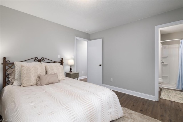 bedroom with ensuite bathroom and dark hardwood / wood-style floors