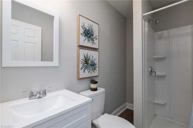 bathroom featuring a shower, vanity, and toilet