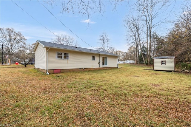 rear view of property with a yard and a shed