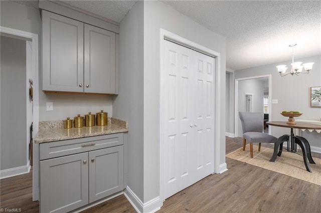 kitchen featuring gray cabinetry, hardwood / wood-style floors, and a textured ceiling