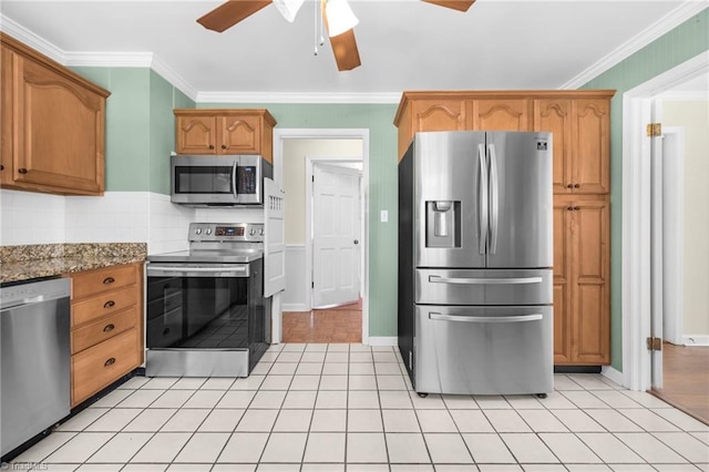 kitchen featuring appliances with stainless steel finishes, backsplash, ceiling fan, dark stone counters, and crown molding