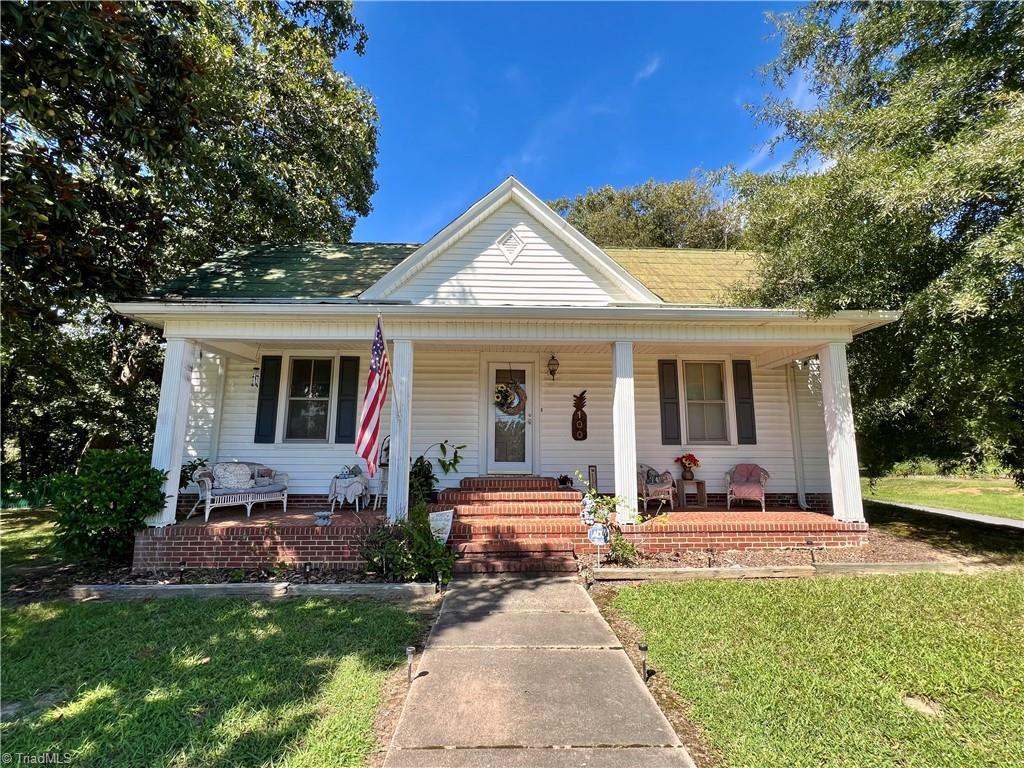 bungalow with a porch and a front lawn