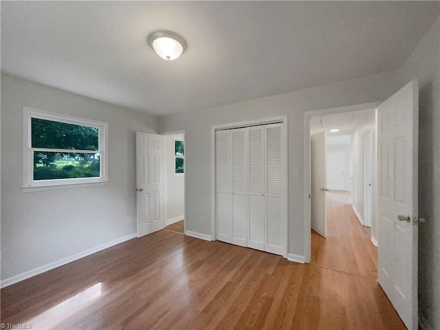 unfurnished bedroom featuring light hardwood / wood-style floors and a closet