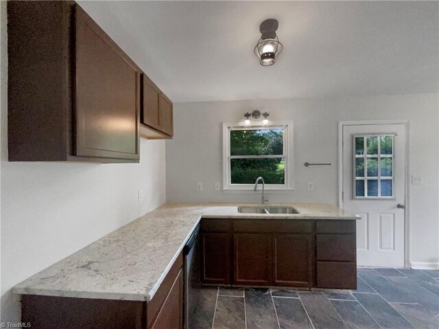 kitchen featuring stainless steel dishwasher, tile patterned floors, sink, kitchen peninsula, and dark brown cabinets