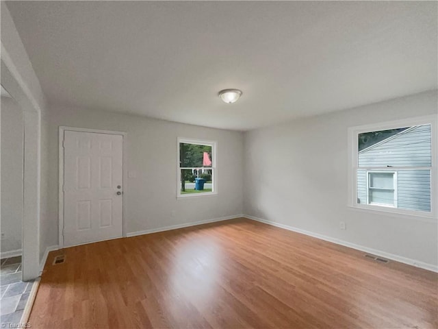 spare room featuring plenty of natural light and hardwood / wood-style flooring