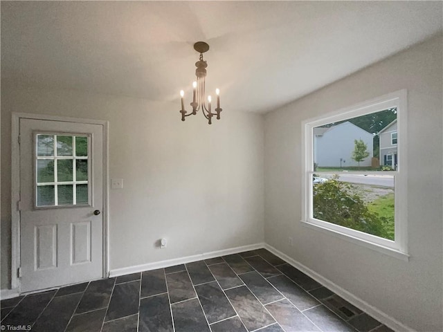 tiled spare room with an inviting chandelier