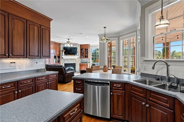 kitchen featuring dishwasher, tasteful backsplash, a fireplace, and a sink