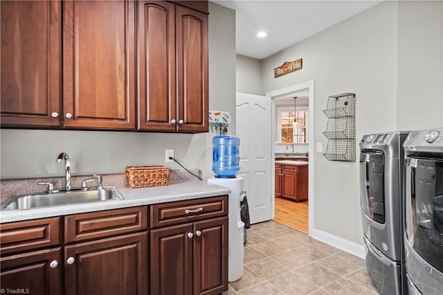 washroom featuring washer and dryer, cabinet space, a sink, and light tile patterned floors