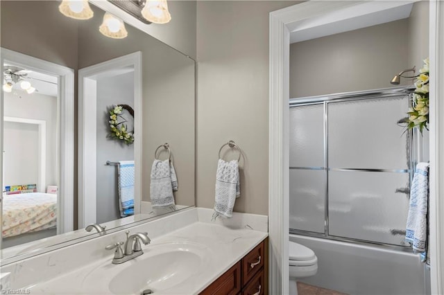 ensuite bathroom featuring enclosed tub / shower combo, vanity, toilet, and ensuite bathroom