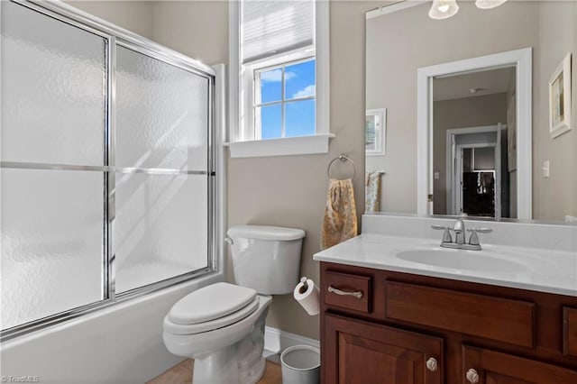 bathroom featuring vanity, toilet, and bath / shower combo with glass door