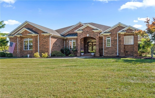 view of front facade with brick siding and a front lawn