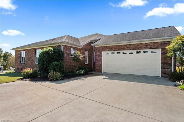 ranch-style house featuring brick siding, driveway, and an attached garage