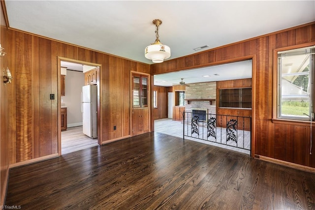 8521 US Highway 64 E, Ramseur, NC 27316 - unfurnished living room with wooden walls, a fireplace, wood finished floors, ceiling fan, and baseboards