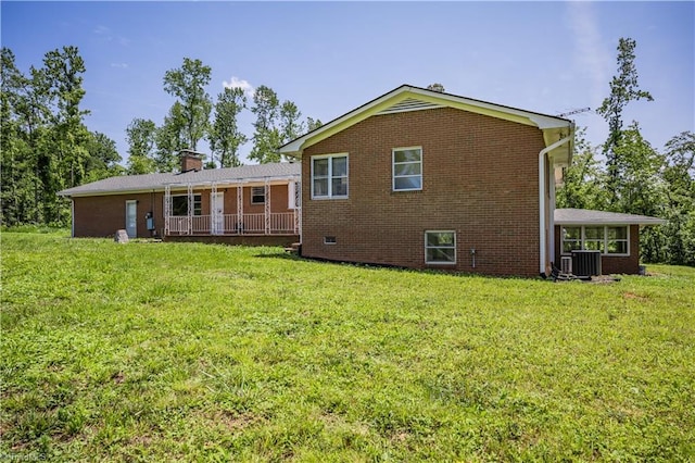 8521 US Highway 64 E, Ramseur, NC 27316 - back of house featuring brick siding, a lawn, central AC unit, and a chimney