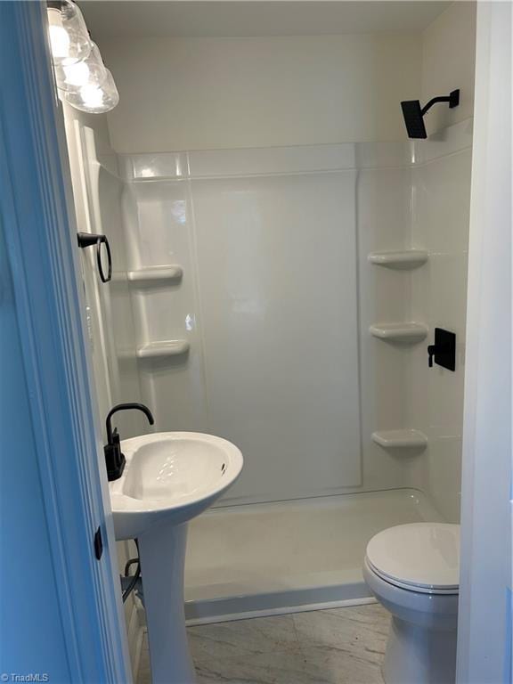 bathroom featuring a shower stall and toilet