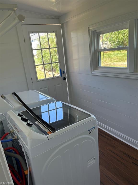 laundry room with dark wood finished floors, washer / dryer, laundry area, and a healthy amount of sunlight